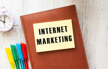 Notepad with text INTERNET MARKETING on a white background, near laptop, calculator.