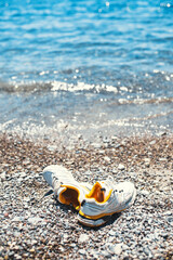 Rest and relaxation after a long hard hike by the sea - the legs of the traveler in sneakers