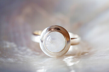 Obraz na płótnie Canvas Silver ring with moon stone gemstone on pearl white background