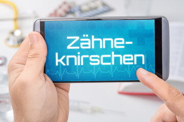 Smartphone mit dem Text Zähneknirschen auf dem Display