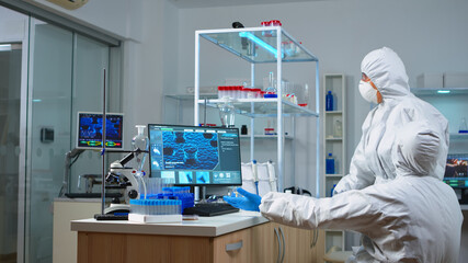 Chemist coworkers in ppe suit planning conducting vaccine against new virus in modern equipped...