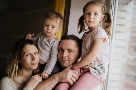 beautiful caucasian family portrait. Young mom and dad holding kids on shoulders. Image with selectie focus and toning 
