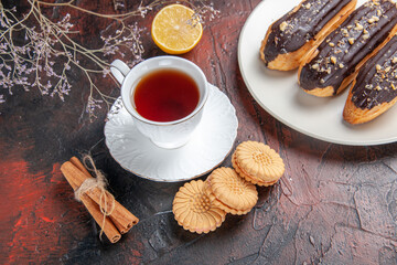 top view cup of tea with cookies and eclairs on dark floor sugar tea biscuit sweet