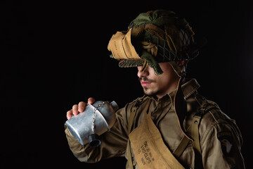 World War II, American 101 Airborne soldier drink water from his cantine.