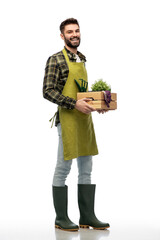 gardening, farming and people concept - happy smiling male gardener or farmer in apron and rubber boots with box of garden tools over white background