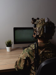 US Army special forces operator looking at the computer screen in the office. Seal team operator in...