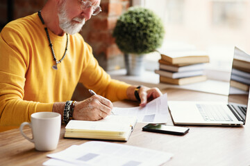 Smart aged freelancer doing paperwork.