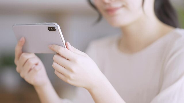 スマートフォンで動画を観る若い女性