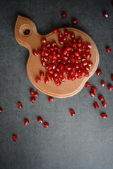 Ripe pomegranate seeds on a cutting board on the table
