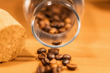 Roasted coffee beans on table with jar