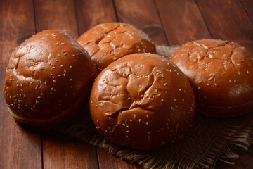 A stack of burger buns. Round bread on wooden board