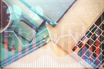 Double exposure of forex graph drawing over desktop background with computer. Concept of financial analysis. Top view.
