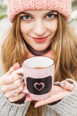 beautiful woman with cup of hot tea in woolen hat