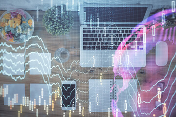 Stock market graph and top view computer on the table background. Multi exposure. Concept of financial education.