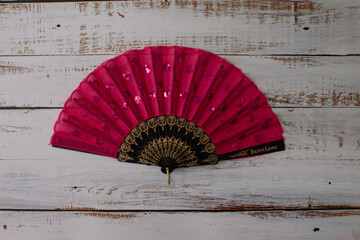 red spanish fan on a light wooden background