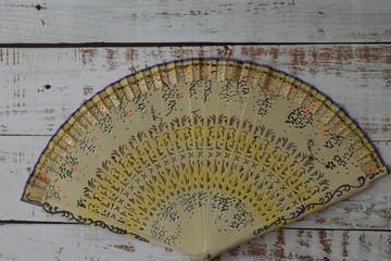 Spanish fan in yellow tones on white wood