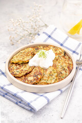 Vegetarian zucchini fritters or pancakes topped with sour cream.