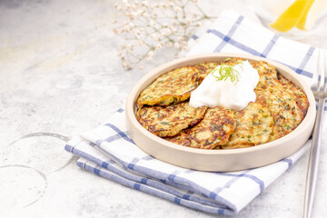 Vegetarian zucchini fritters or pancakes topped with sour cream.
