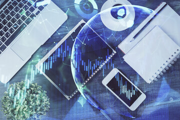 Double exposure of forex chart hologram over desktop with phone. Top view. Mobile trade platform concept.