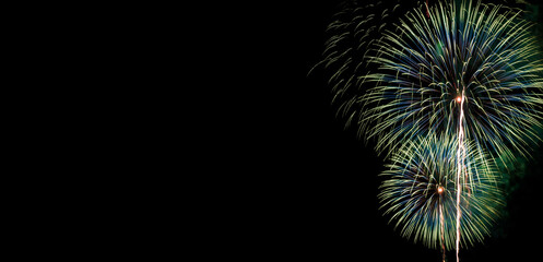 Abstract beautiful colorful fireworks display for celebration on black background with free space for text. New year holiday concept.