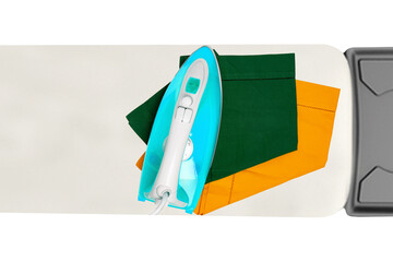 Top view of a modern electric blue iron ironing a green and a yellow cloth napkin on an ironing...