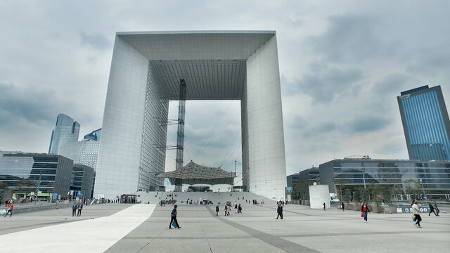 Paris, France - May 11, 2017: people walking in La Defense in Paris with Arche de la D&eacute;fense at background
