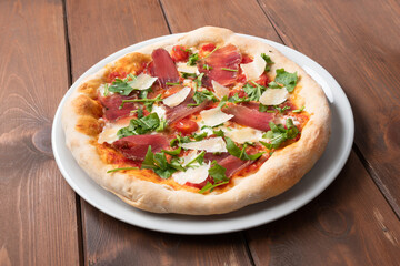 Deliziosa pizza italiana condita con fettine di lonza di maiale, rucola e grana 