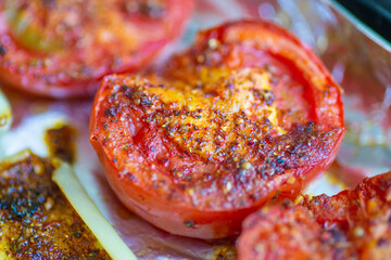 Baked tomato with seasoning close-up