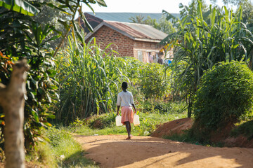 Fototapeta na wymiar Woman carrying water in Uganda, Africa