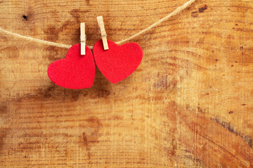 Dos corazones rojos colgados sobre un fondo rústico de madera. Vista de frente. Copy space. Concepto:  Día de San Valentín, matrimonio, día de la madre, concepto de amor.