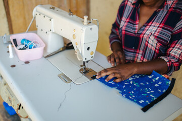 woman using an old sewing machine in Uganda, Africa