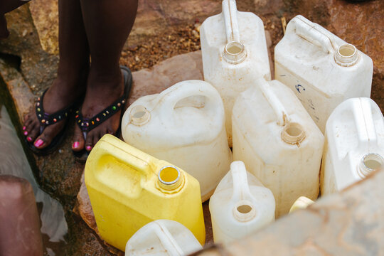 People filling water cans at a well in Uganda, Africa