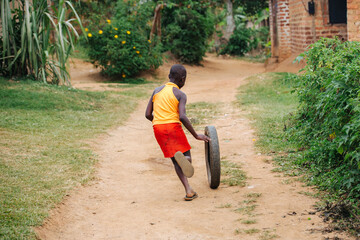 child playing with a tire in Uganda, Africa	