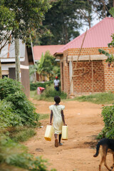 Fototapeta na wymiar Child carrying water cans in Uganda, Africa