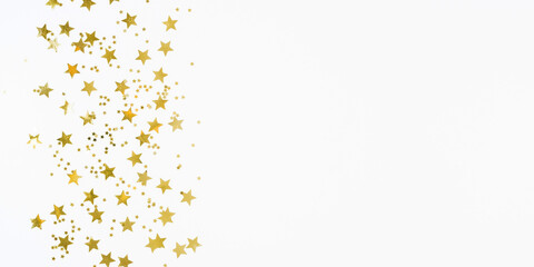 Festive background with gold stars confetti. Shining golden stars on white background. Flat lay, top view, copy space.