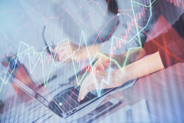 Multi exposure of woman hands typing on computer and financial chart hologram drawing. Stock market analysis concept.