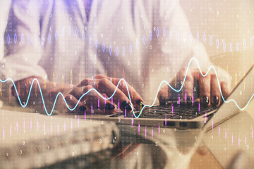 Double exposure of woman hands typing on computer and forex chart hologram drawing. Stock market...