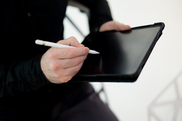 Copy space screen of tablet. Close up shot of male hands signing on gadget using stylus. Cut view of man in dark clothes. Don't recklessly sign e-invoices Financial literacy concept.