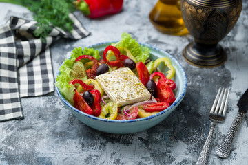 Greek salad with feta on grey concrete table