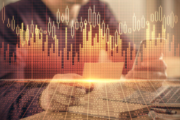 Double exposure of man's hands holding and using a phone and financial graph drawing. Analysis...