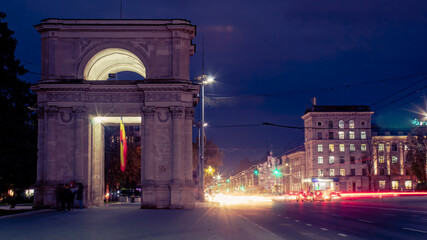Arch and street with cars in the evening in Chisinau