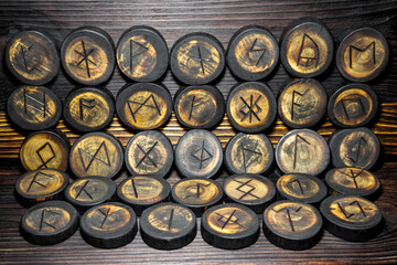 Runes carved from wood on the vintage wood background, Anglo-Saxons Futhark
