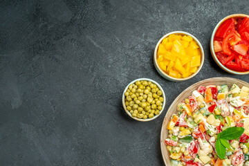 top close view of vegetable salad with different vegetables on side with free space for text on the left side on the grey background