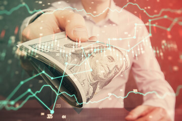 Multi exposure of financial graph drawing hologram and USA dollars bills and man hands. Analysis concept.