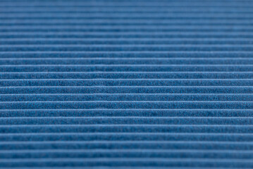 Background made of blue corrugated cardboard with horizontal stripes, shallow depth of field.