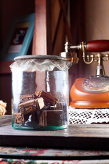 Fototapeta na wymiar Glass jar with vintage toy suitcases. Interior decor in old style