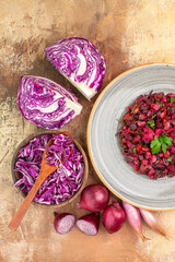 top view beetroot salad with parsley leaves on top with ingredients on a wooden table with copy space