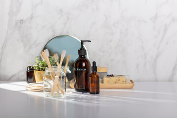 Different kinds of hygiene and cosmetic products near white marble wall in bathroom, zero waste...
