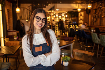 Portrait of a confident young woman standing in the doorway of a coffee shop. Portrait of Smiling cafeteria owner. Small business owner at entrance looking at camera