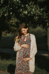 Beautiful pregnant girl wearing dress with flowers